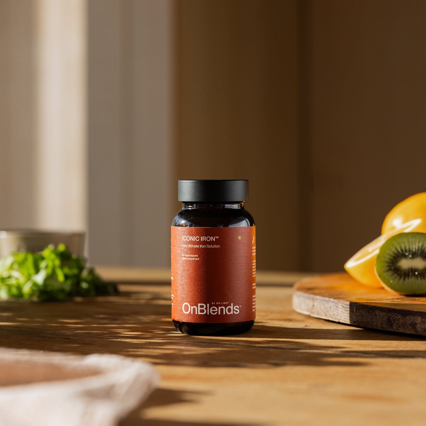 
                  
                    OnBlends Iconic Iron bottle on a kitchen bench in morning light with fresh produce
                  
                